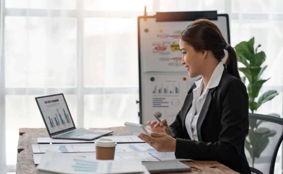 Mulher vestida como executiva, fazendo a sua declaração do imposto de renda para não cair na malha fina da Receita Federal.